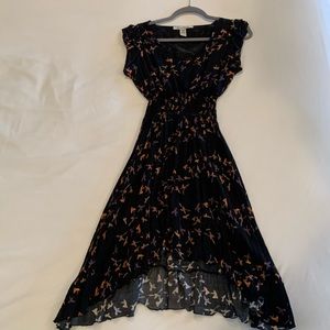 Black dress with cap sleeve, smocked waist and high low hemline.